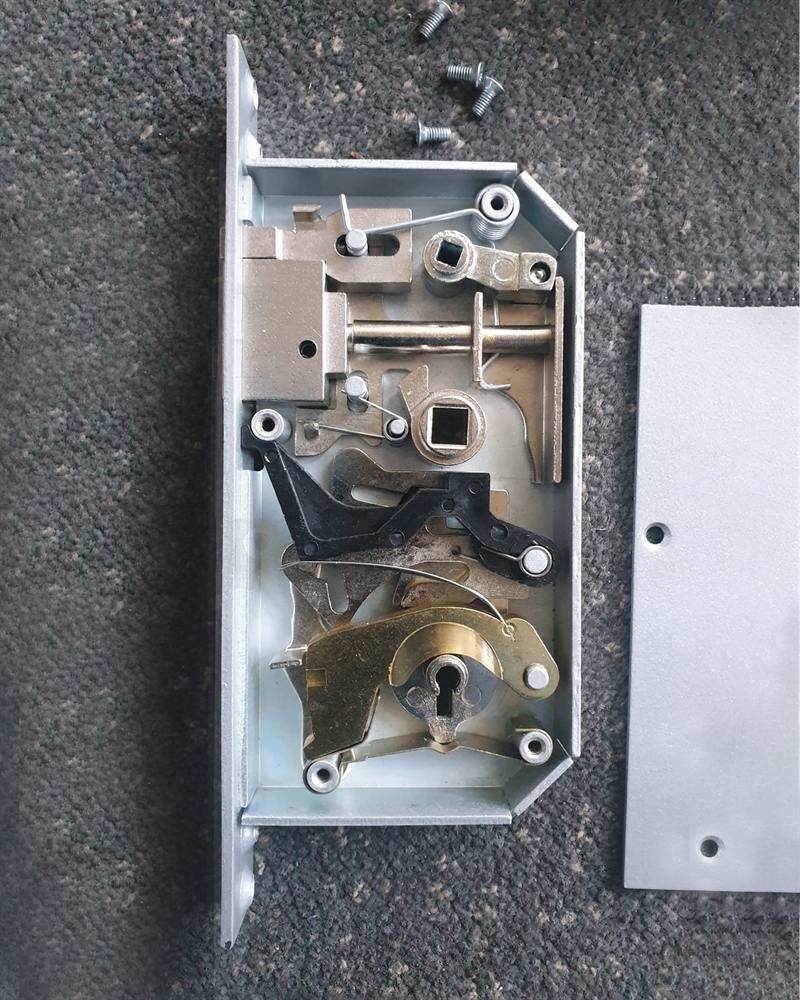 A commercial mortice lock opened up on the bench for repair.